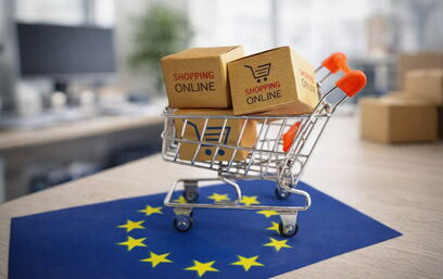 Online-Shopping-Warenkorb mit Paketen auf EU-Flagge vor unscharfem Bürohintergrund als Symbol für neue E-Commerce-Vorgaben