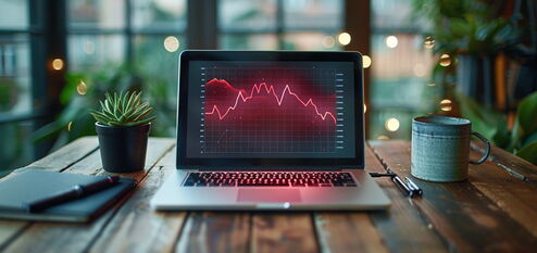 Laptop mit fallenden Diagramm auf Schreibtisch – Symbol für sinkende Impressionen in der Google Search Console